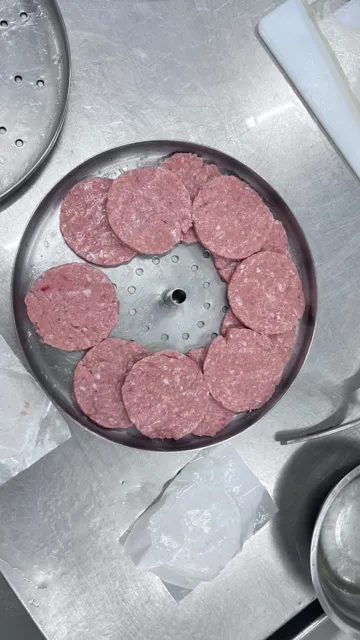 Hamburguesas recién formadas sobre una bandeja.