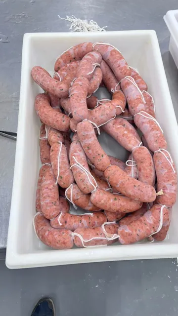 Chorizos recién elaborados y atados en sus bandejas.