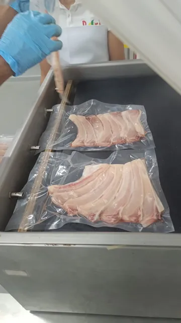 Bolsas con costillas dentro de la cámara de envasado al vacío.