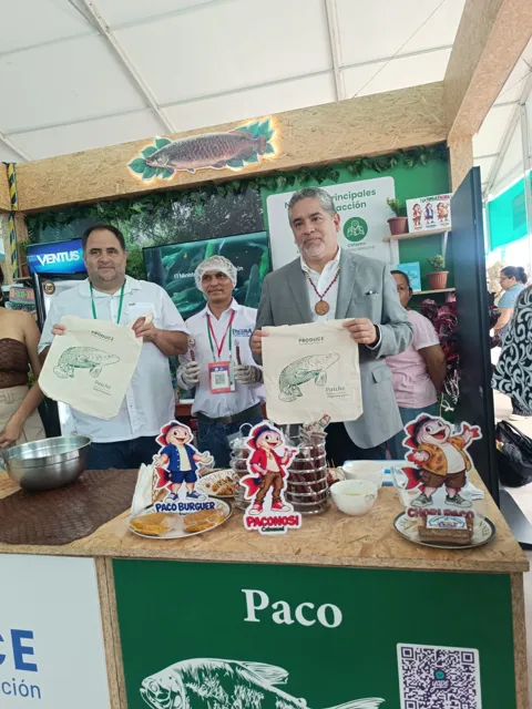 Visitantes junto al equipo y los productos de PACORA.